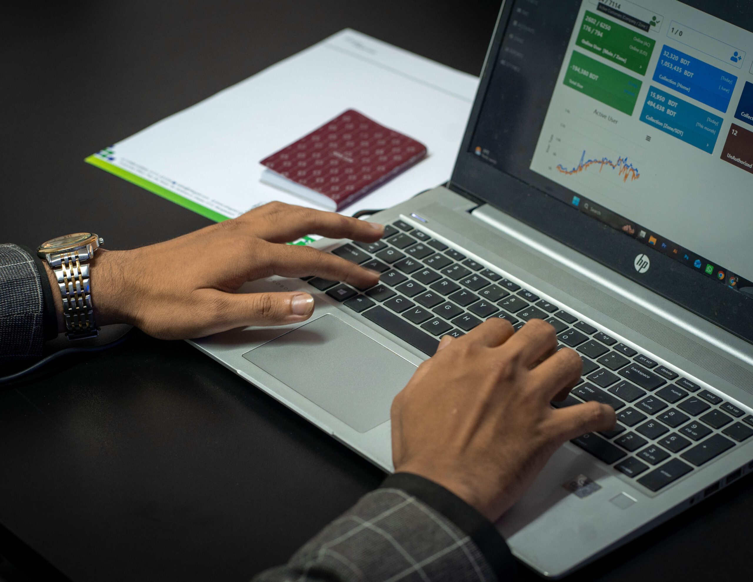 Hands typing on a laptop displaying a data dashboard of digital marketing campaign.